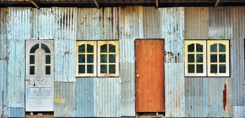Old doors and windows Installed on the wall of the house that is old zinc as wel Old doors and windows Installed on the wall of the house that is old zinc as wel