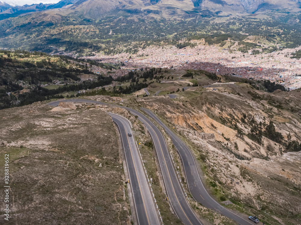 Aerial view of the roadway to Huaraz city with green mountains in the background in the Peruvian Andes