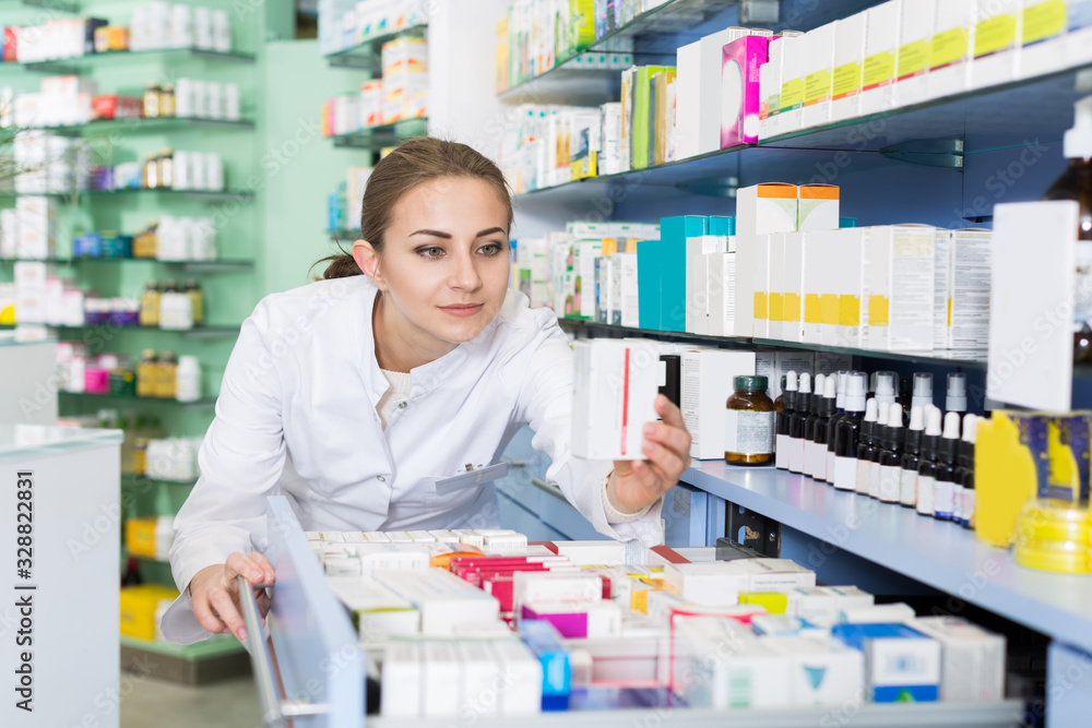 Woman chemist is searching medicine in drawers