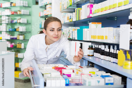 Woman chemist is searching medicine in drawers