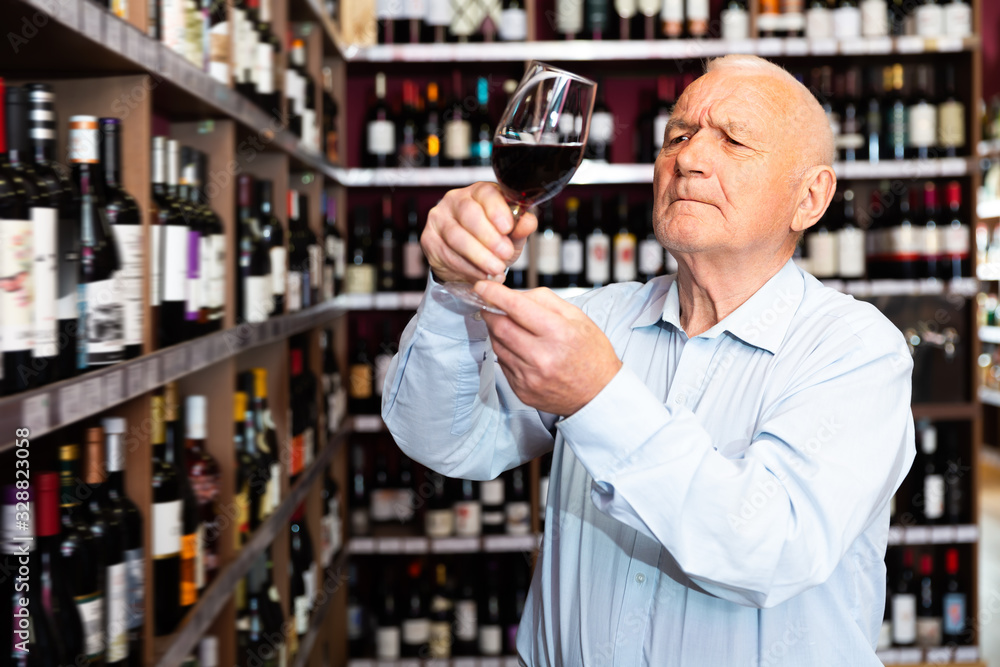 Portrait of mature man tasting red wine