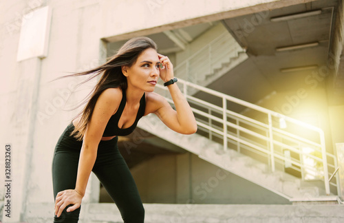 Free Download Portrait of a tired sport woman resting after jogging outdoors among urban environment - GFXLoad