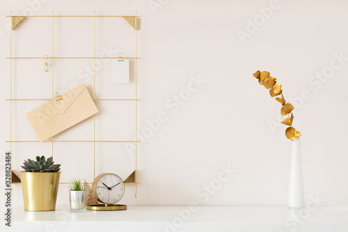 Stylish desk interior with White table background with plant and leaves. Modern home office interior © uv_group