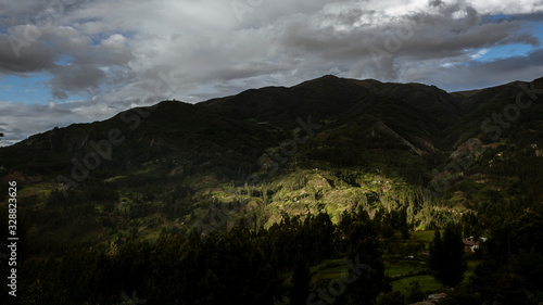 Andean forest and cropfields with dramatic light in Conchucos Valley, Ancash Region, Peru