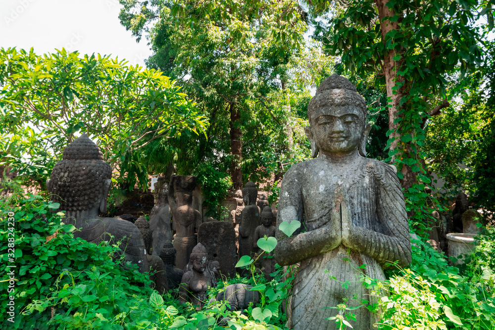 Buddha Statues hidden in leaves of tropical jungle, with mist in the morning ,selective focus