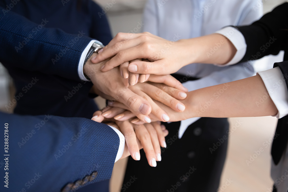 Close up of diverse businesspeople stack hands show unity and support in work, supportive motivated multiracial colleagues coworkers engaged in teambuilding activity at meeting, teamwork concept Close up of diverse businesspeople stack hands show unity and support in work, supportive motivated multiracial colleagues coworkers engaged in teambuilding activity at meeting, teamwork concept