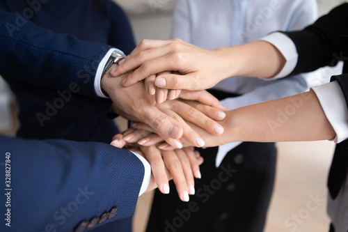 Close up of diverse businesspeople stack hands show unity and support in work  supportive motivated multiracial colleagues coworkers engaged in teambuilding activity at meeting  teamwork concept