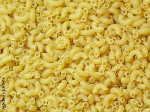 Macaroni background. Raw macaroni close- up top view. Dry ingredients for cooking. Pasta. Copy space. Abstract background. Cooking and cuisine. Background for the design.