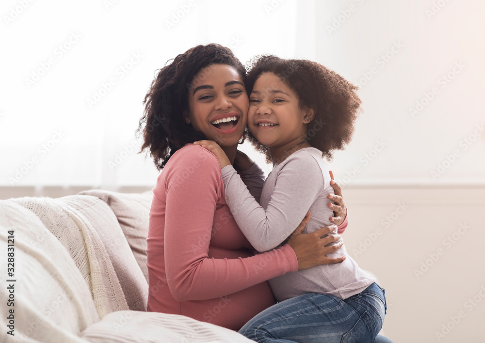 Adorable Black Little Girl Hugging Pregnant Mother And Laughing At Home Adorable Black Little Girl Hugging Pregnant Mother And Laughing At Home