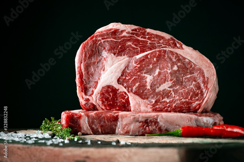 Raw rib eye beef steak on a black background photo