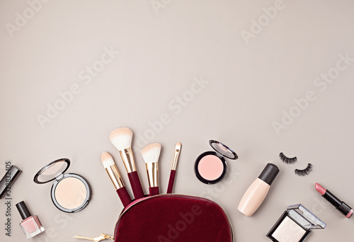 Flat lay with set of professional decorative cosmetics, makeup tools and woman accessories over gray background with copy space. Beauty blog, fashion, party and shopping concept