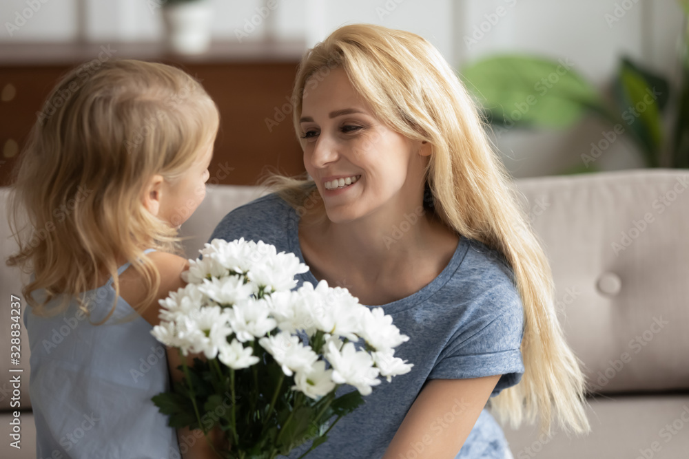 Cute little girl child make birthday surprise congratulate happy young mom give flowers, small daughter greeting excited mother present bouquet for anniversary or special occasion, celebration concept Cute little girl child make birthday surprise congratulate happy young mom give flowers, small daughter greeting excited mother present bouquet for anniversary or special occasion, celebration concept