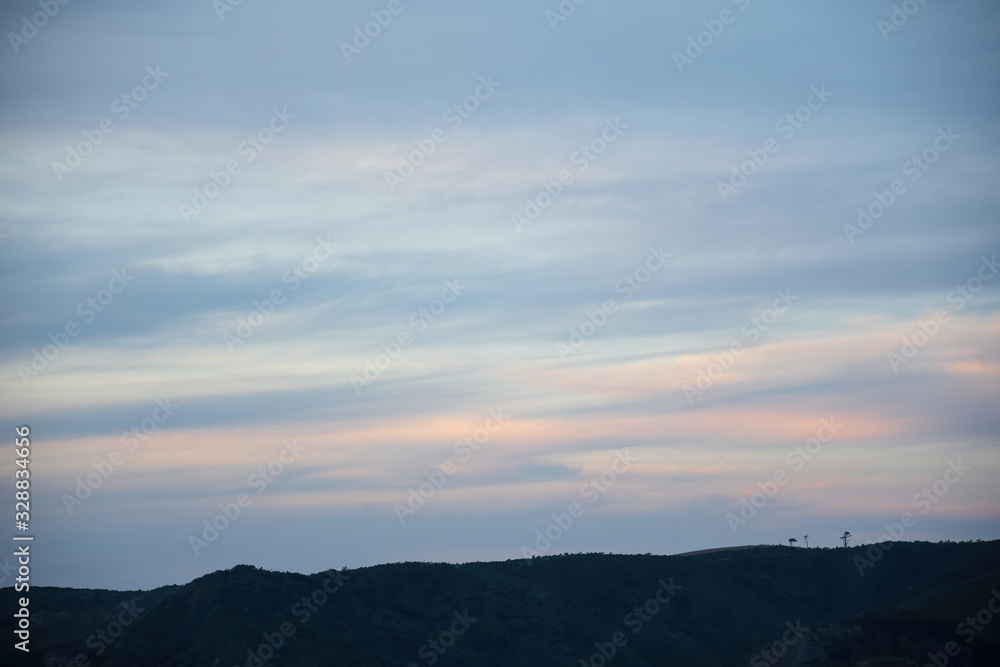 View of pastel sky over hill ridge after sunset