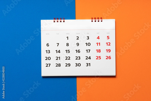close up of calendar on the blue and orange table background, planning for business meeting or travel planning concept