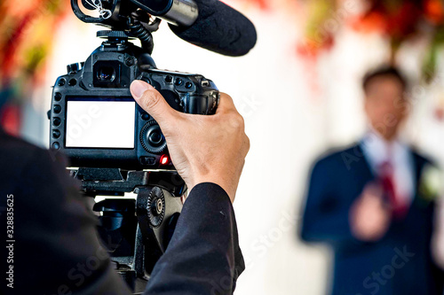 Female Videographer in backside are shooing and recording video in Wedding Event. photo