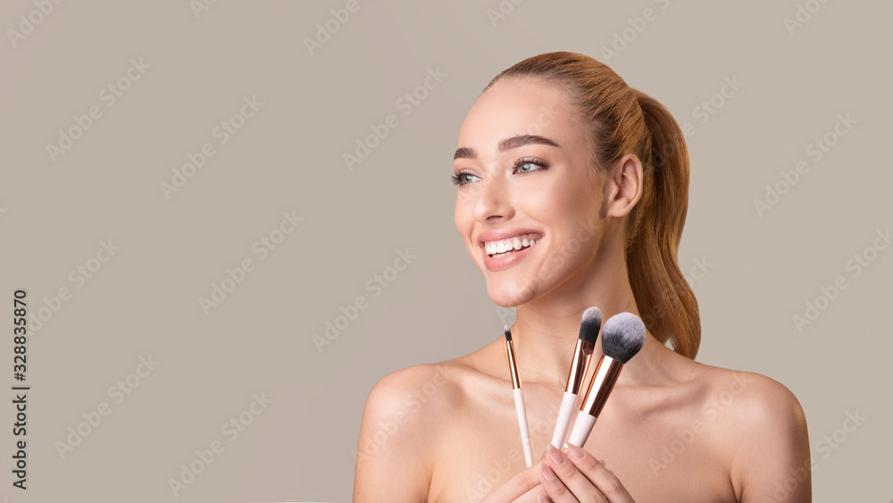 Smiling Girl Holding Cosmetic Brushes Posing Over Beige Background, Panorama Smiling Girl Holding Cosmetic Brushes Posing Over Beige Background, Panorama