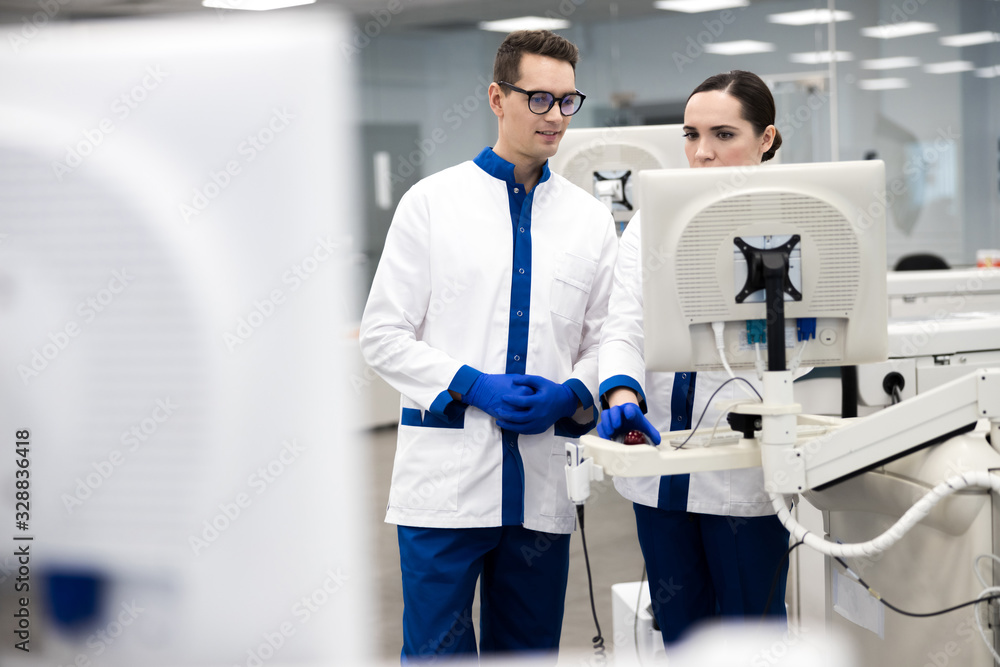 Fototapeta premium Research scientists using automated immunoassay system in lab