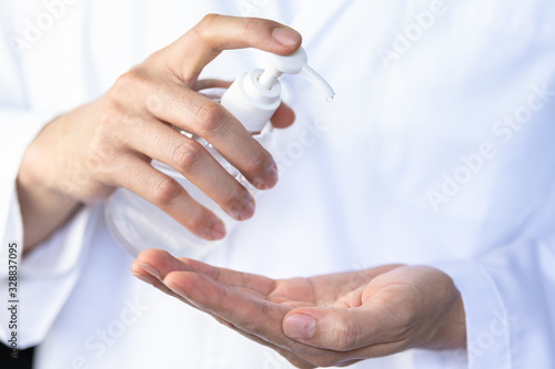 Man, doctor nurse hands using wash hand sanitizer gel pump dispenser for protection coronavirus and bacteria, health care concept