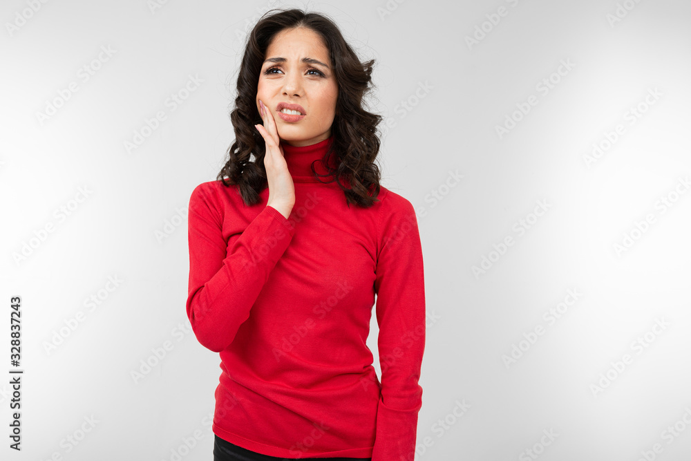 sad girl with a bad tooth stands on a gray background with copy space sad girl with a bad tooth stands on a gray background with copy space