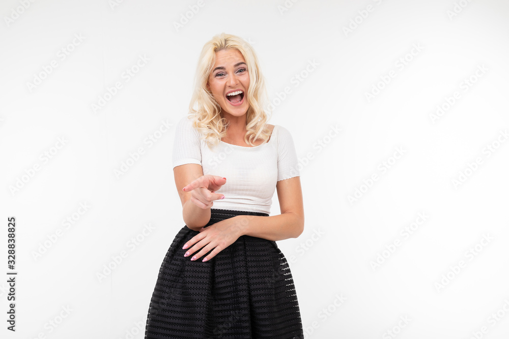girl dressed in a white T-shirt and black skirt smiles amiably on a white background with copy space