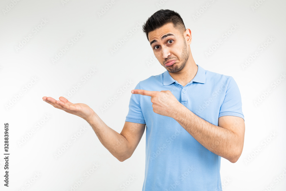 man in a blue t-shirt with holding hands on a white studio background man in a blue t-shirt with holding hands on a white studio background