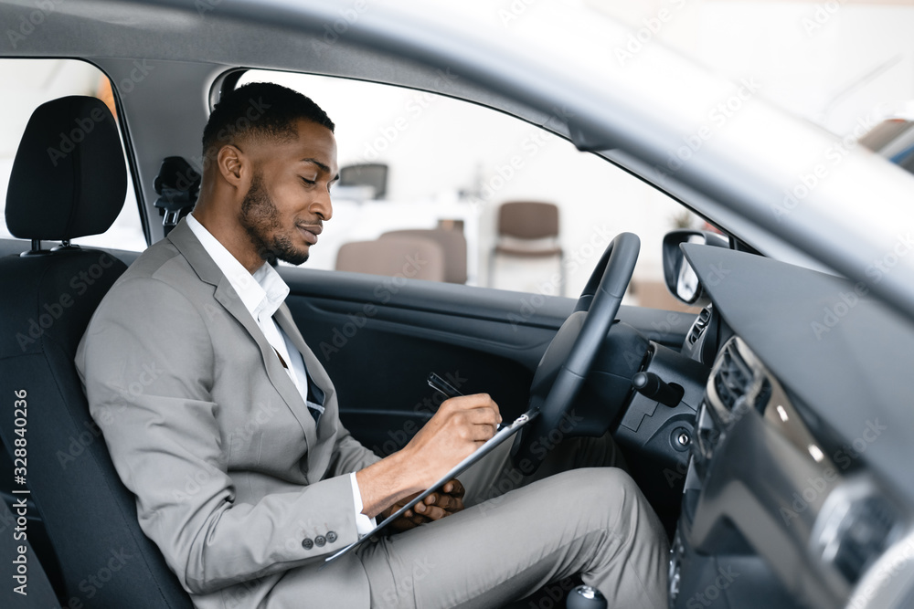 Professional Car Seller Sitting In Auto Taking Notes In Dealership Professional Car Seller Sitting In Auto Taking Notes In Dealership