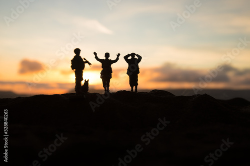 Battle scene. Military silhouettes fighting scene on war fog sky background. A German soldiers raised arms to surrender.