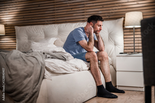 Exhausted guy in cozy bedroom stock photo