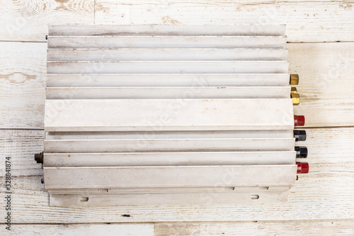 Old white 12v power amplifier on wood floor, hi grade grade technology photo