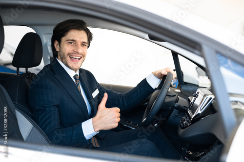 Businessman Buying Car Gesturing Thumbs-Up In Driver's Seat © Prostock-studio