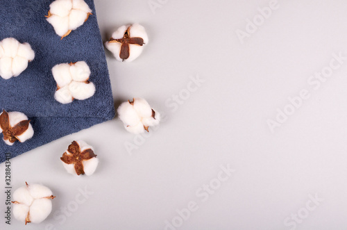 Spa concept idea, cotton and towel composition on grey background.