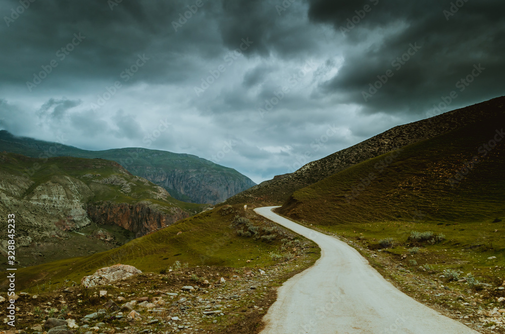 Cycling mountain road. Misty mountain road in high mountains.. Cloudy sky with mountain road Cycling mountain road. Misty mountain road in high mountains.. Cloudy sky with mountain road