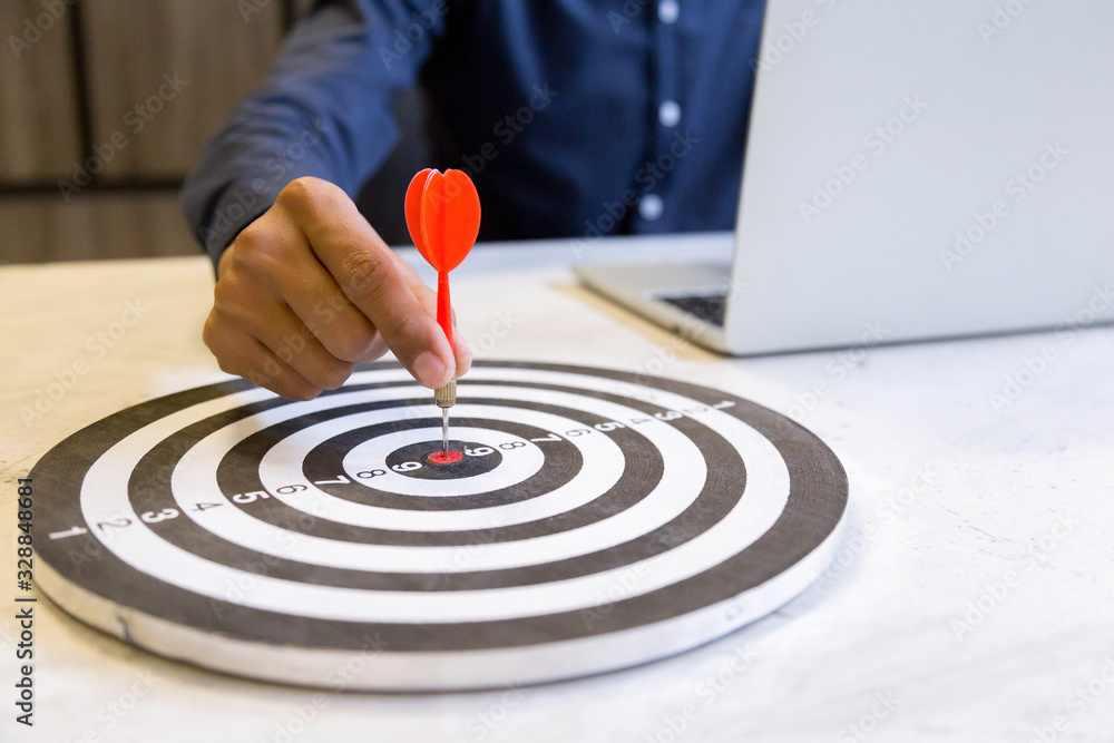Businessman holding a darts aiming at the target center,business growth success concept. Businessman holding a darts aiming at the target center,business growth success concept.