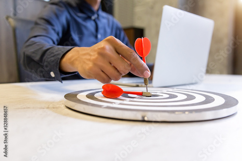 Businessman holding a darts aiming at the target center,business growth success concept. photo