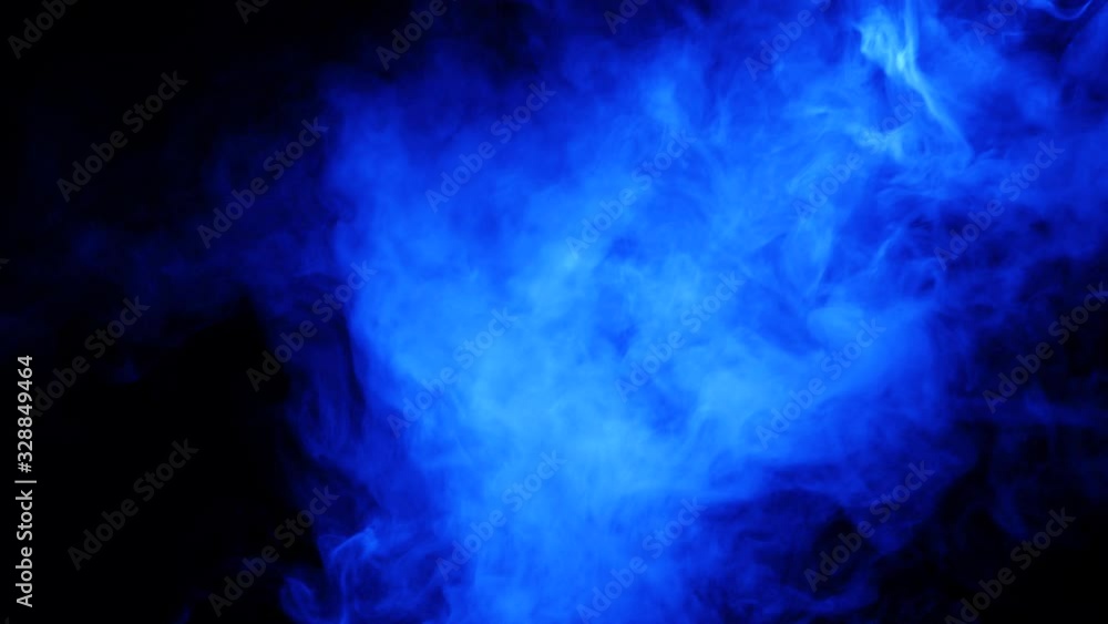 Blue smoke on a black background. Color smoke slowly floating through space against black background.