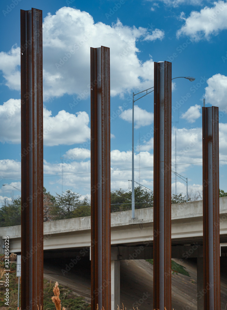 Fototapeta premium Four Steel Beams Poking into the Sky by a bridge