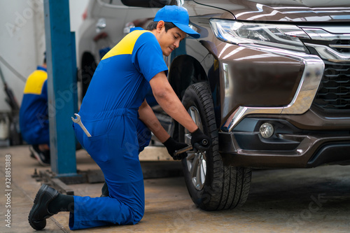 Mechanician changing car wheel in auto repair shop