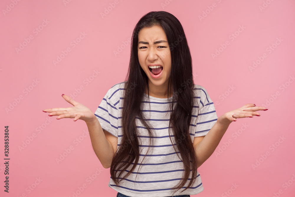 What do you want? Portrait of enraged irritated girl with brunette hair raising hands in questioning gesture, scolding and screaming, having conflict. indoor studio shot isolated on pink background What do you want? Portrait of enraged irritated girl with brunette hair raising hands in questioning gesture, scolding and screaming, having conflict. indoor studio shot isolated on pink background