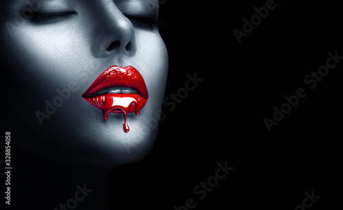 Red Lipstick dripping. Paint drips, lipgloss dripping from sexy lips, Blood liquid drops on beautiful model girl's mouth, creative abstract make-up. Beauty woman face makeup close up, vampire