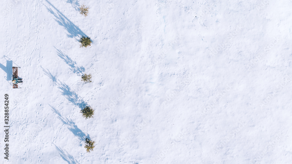Beautiful landscape with trees, benches, hard shadow and snow. Snowy forest. Outside travel background. Cold weather. Aerial view of winter park. Drone view. Stock photo. Beautiful landscape with trees, benches, hard shadow and snow. Snowy forest. Outside travel background. Cold weather. Aerial view of winter park. Drone view. Stock photo.