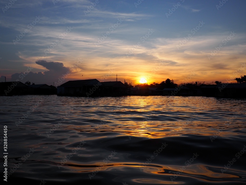 Sunset from a river over fishing village in chau doc, vietnam