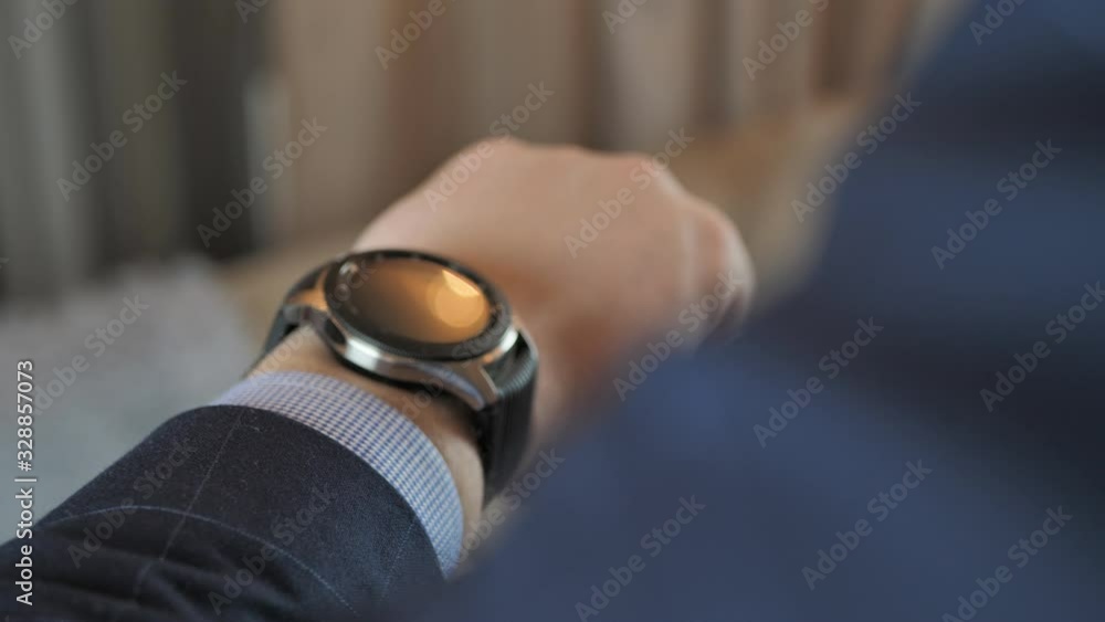 businessman sets up a smart watch before going to work businessman sets up a smart watch before going to work