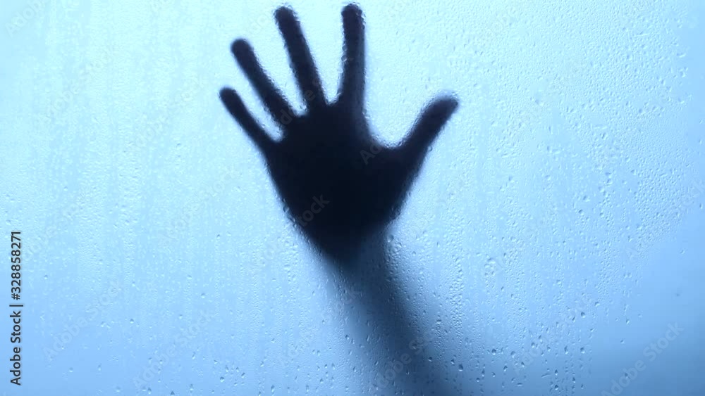 Hand moving down behind a glass with water drop Hand moving down behind a glass with water drop