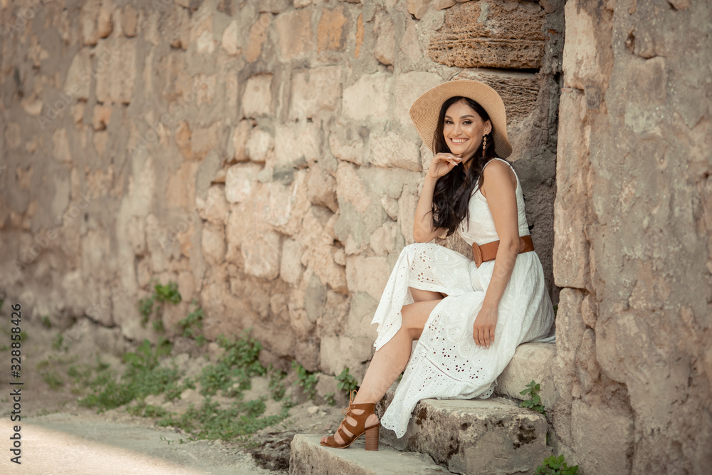 Beautiful woman of eastern appearance among ancient street stone architecture.