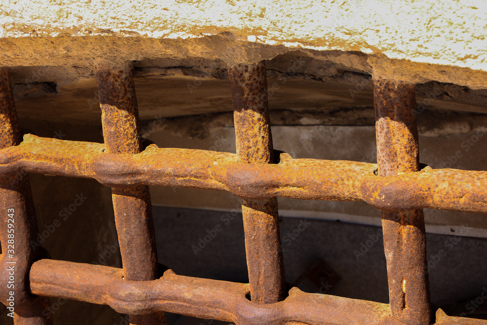 thick bars of rusty iron in a window thick bars of rusty iron in a window