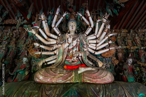 Foto Fine ancient figure of buddhist goddess with 24 arms
