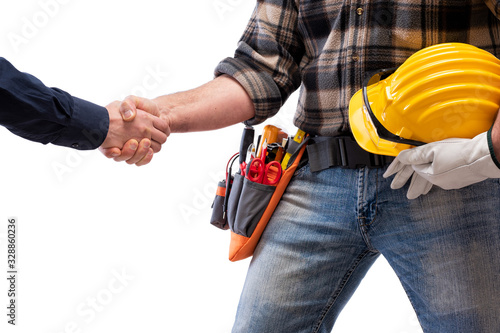 Close-up of a handshake of the electrician carpenter holding helmet and protective goggles in hand. Construction industry, electrical system. Isolated on a white background.