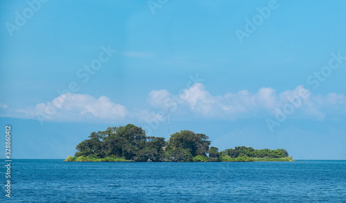 A Beautiful Green Island in the Beautiful Blue Tropical Waters of Lake Toba in Indonesia