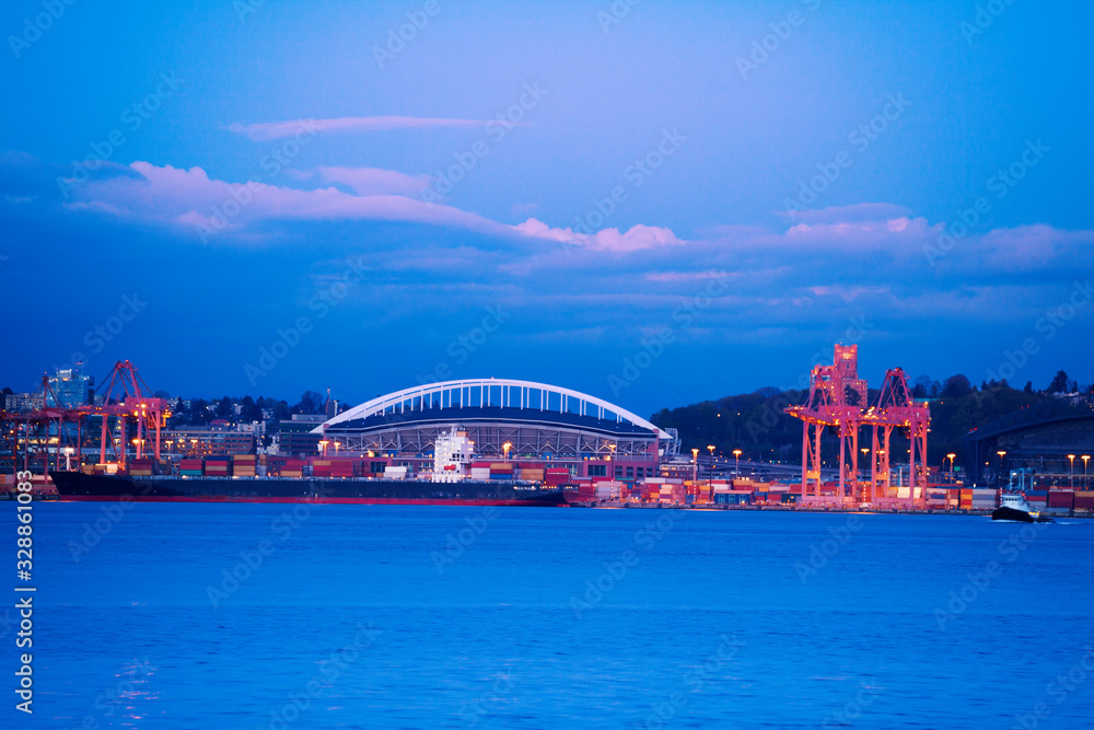 Obraz premium West Seattle bridge and port cranes over Elliot bay at evening time, Washington, USA