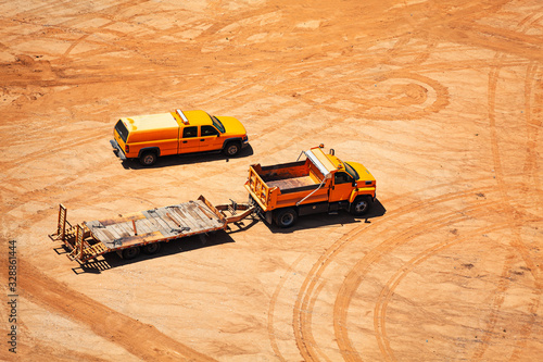 Construction vehicles and car traces on ground side over dust clay with sand view from above